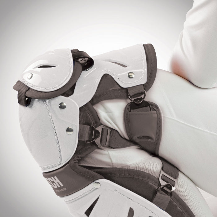 Close-up of a person wearing All Star AFx Fastpitch Catcher's Leg Guards (LGW-AFX) in white and gray with LINQ™ technology, padded knee/thigh guards, and secure straps, set against a plain light background.