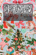 A Christmas-themed transfer paper sheet featuring a busy holiday pattern with a robin, carousel horse, ornaments, gifts, gingerbread men, bows, and a central title panel reading 'Iron Orchid Designs Transfer Darling Holiday' and 'Eight 8" x 12" sheets'.
