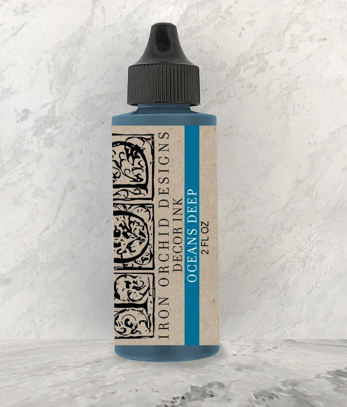 Bottle of Iron Orchid Designs decor ink with a textured white background