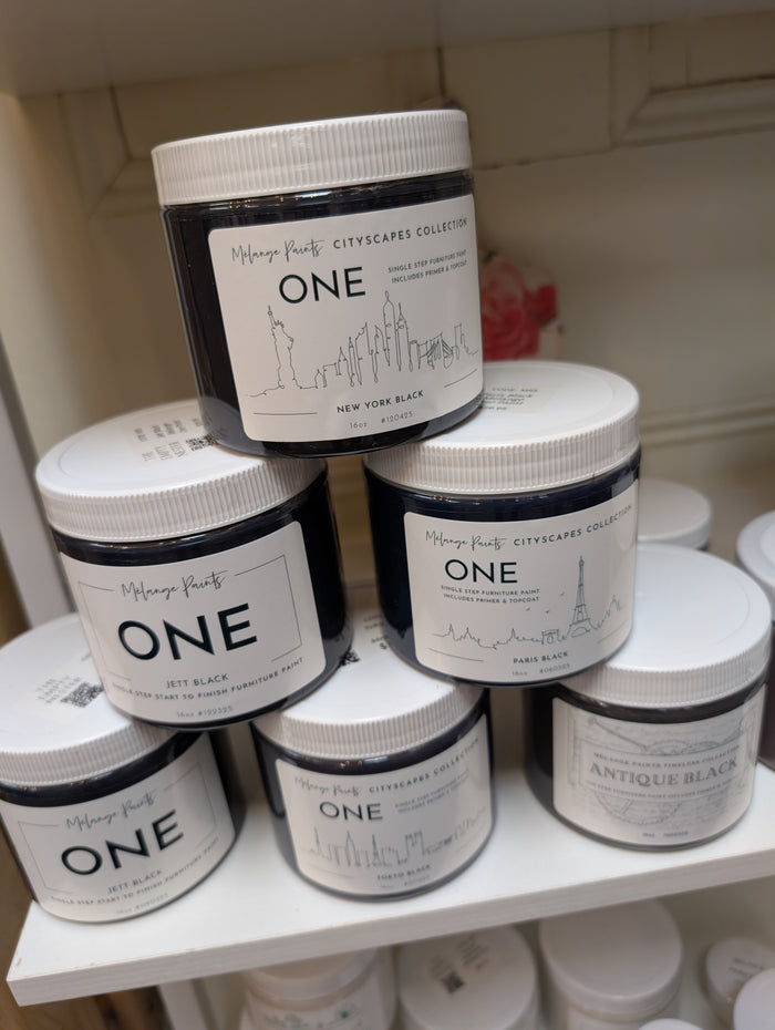 Multiple jars of 'ONE' paint on a shelf with visible branding.