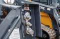 John Deere G Series skid steer with coupler guard installed, showing the quick-attach coupler area