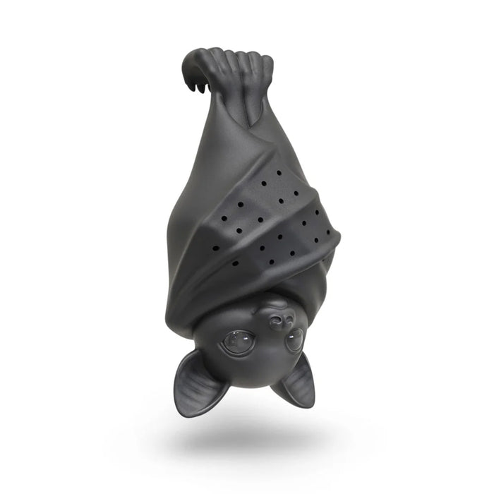 A matte black bat-shaped tea infuser with a perforated body and cute facial features, shown hanging upside down against a white background.