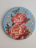 Decorative plate with floral design and butterflies on a light gray background