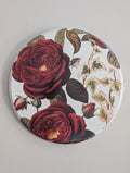 Round wood piece with red rose design on a white background